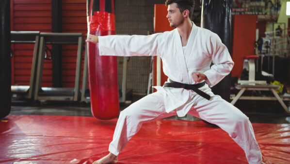 Karate player performing karate stance in fitness studio